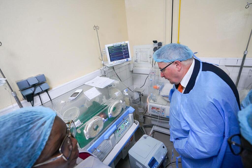 Le directeur exécutif adjoint de l'UNFPA, Andrew Saberton, en tenue médicale, examine un incubateur dans une maternité au Tchad.