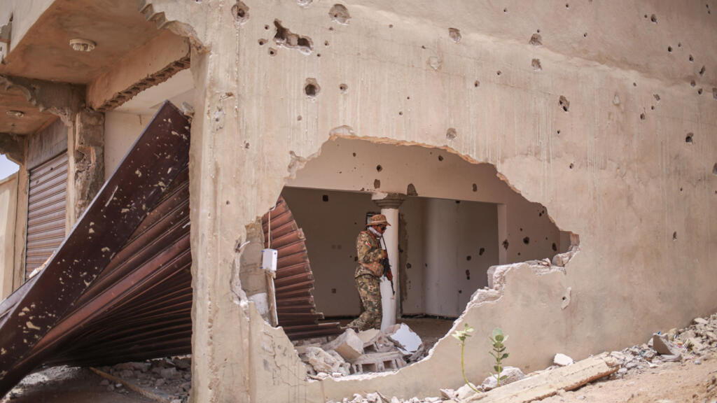 Un soldat du Front national de libération de l'Azawad (FLA) dans un bâtiment endommagé à Kidal, illustrant la crise sécuritaire au Mali.