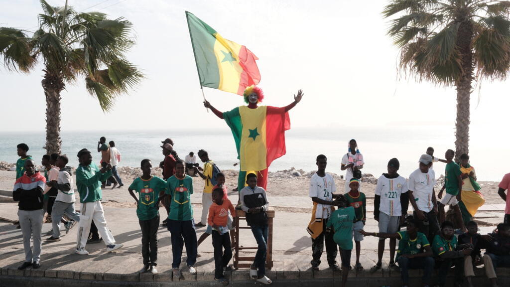 Supporters sénégalais célébrant la victoire de leur équipe lors d'un défilé à Dakar, symbole de l'engouement pour le football dans le pays.