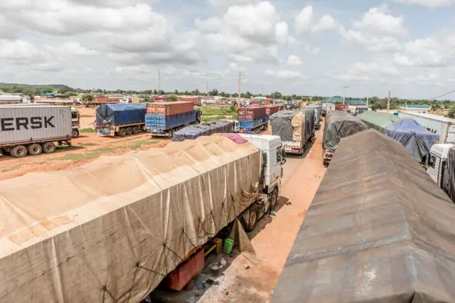 Des centaines de camions bloqués à la frontière entre le Bénin et le Niger, illustrant l'impact économique de la crise.