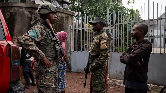 Des militaires en uniforme aux côtés d’un civil dans une zone conflictuelle